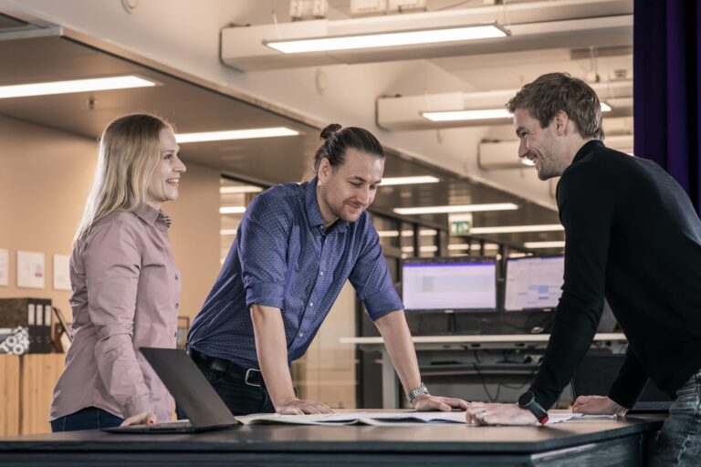 WeGo Groupin asiakkaan LeaseGreenin referenssissä käytetty kansikuva. Kuvassa on tiimi pöydän ympärillä. Taustalla näkyy tietokoneen näytöt ja toimitilaa.