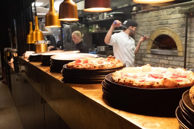 WeGo Groupin asiakkaan MaRan referenssissä käytetty kansikuva. Kuvassa on Fat Lizardin ravintolasta otettu kuva, jossa näkyy kokki, tarjoilija ja etualalla pizzoja.