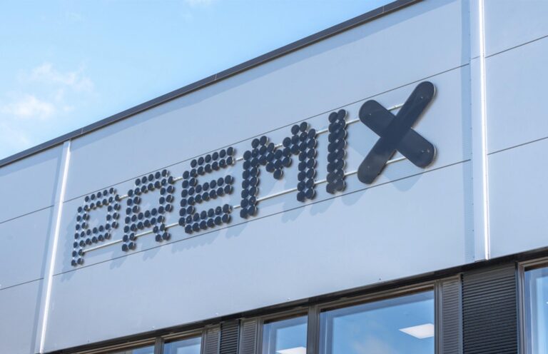 WeGo Groupin asiakkaan Premixin musta logo vaalean rakennuksen seinässä.