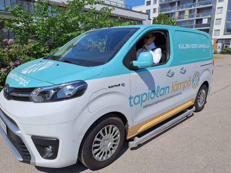 Kuvassa WeGo Groupin asiakkaan Tapiolan Lämmön sähköpakettiauto, jonka kyydissä istuu mies. Auton kyljessä lukee teksti: “Hiilineutraalimpaa kiinteistönhoitoa”.