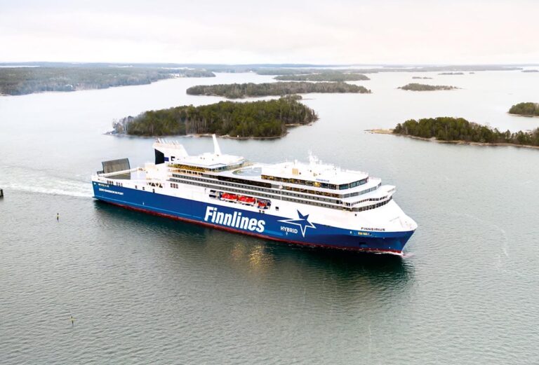 WeGo Groupin referenssin kansikuvana on Finnlinesin Finnsirius-hybridiristeilijä liikennöimässä saariston halki merellä, taustalla näkyy vehreitä saaria ja rauhallinen maisema.